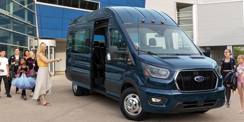 Blue 2026 Ford Transit Van stopped by door opened passenger waiting to step in