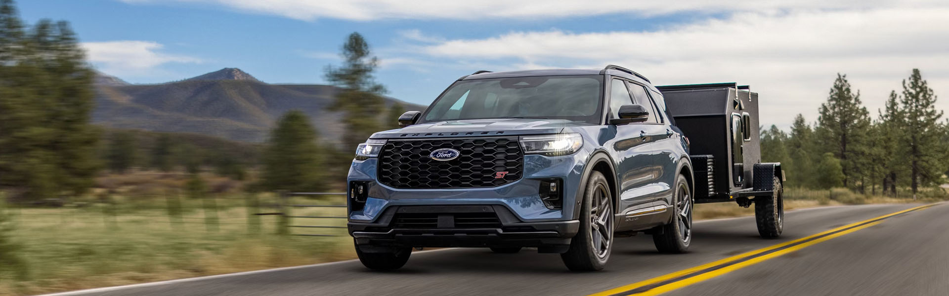 Blue Ford Explorer SUV with trailer.